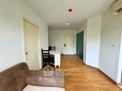 Spacious living room with wooden flooring and modern furniture in a stylish apartment.