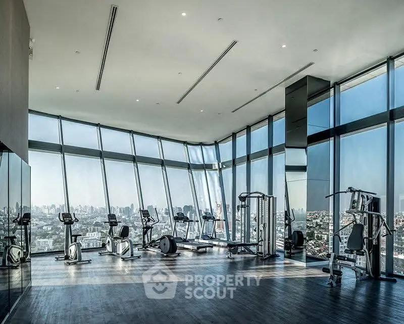Luxurious high-rise gym with panoramic city views and modern fitness equipment.