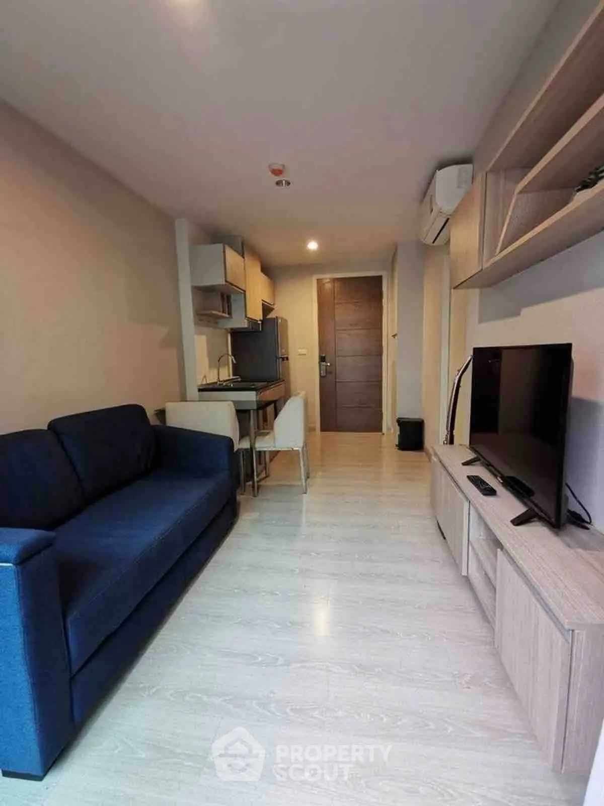 Modern living room with sleek furniture and open kitchen layout in a cozy apartment.