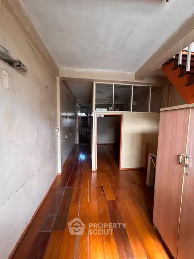 Spacious hallway with wooden flooring and staircase in a residential property