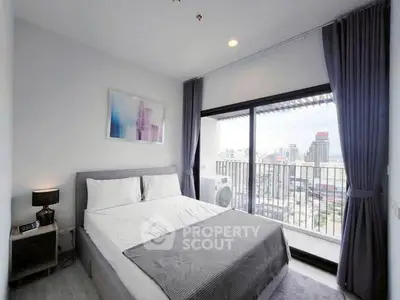 Modern bedroom with balcony and city view, featuring stylish decor and ample natural light.