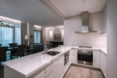 Modern open-layout kitchen with sleek appliances and spacious living area in luxury apartment.