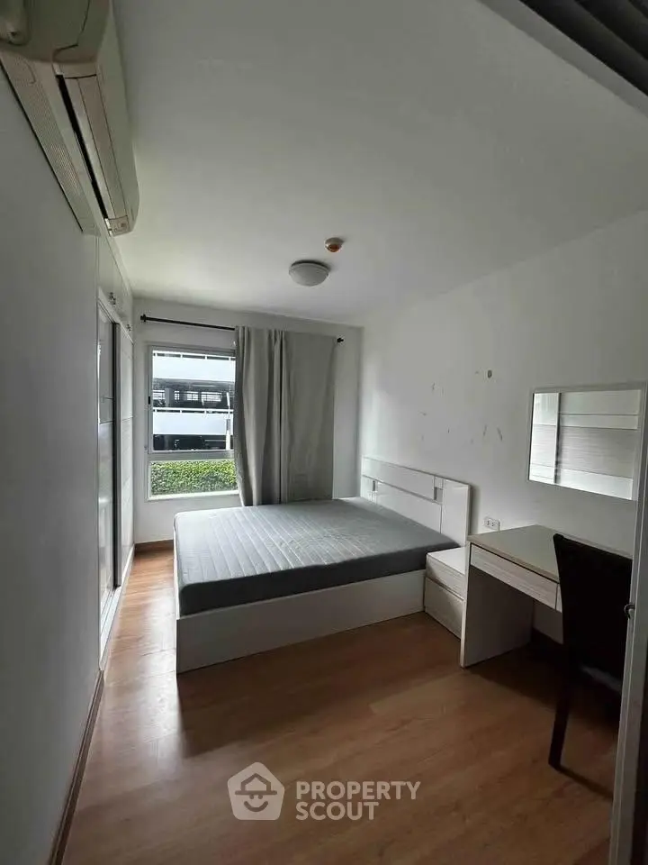 Cozy bedroom with modern furnishings and natural light in a stylish apartment.