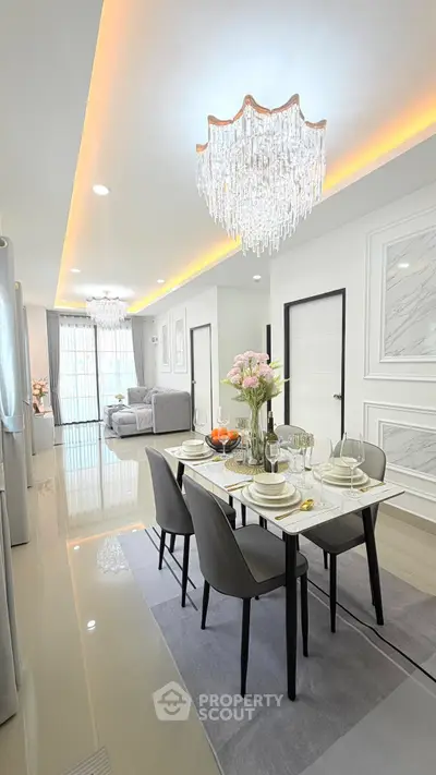 Luxurious dining and living area with elegant chandeliers and modern decor