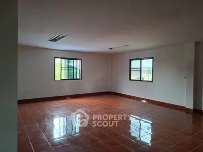 Spacious empty room with tiled floor and large windows, perfect for customization.
