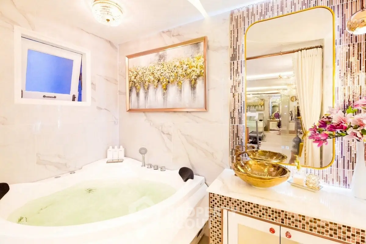 Luxurious bathroom with jacuzzi tub and elegant gold fixtures
