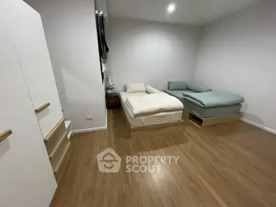 Spacious bedroom with twin beds and modern wooden flooring