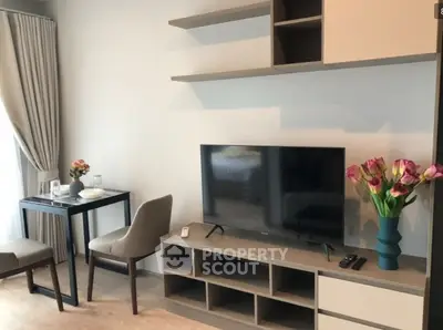 Modern living room with TV, stylish furniture, and elegant decor in a cozy apartment.