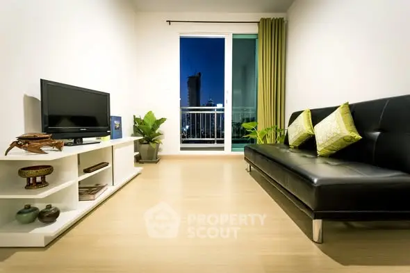 Modern living room with sleek black sofa, TV, and balcony view in a stylish apartment.