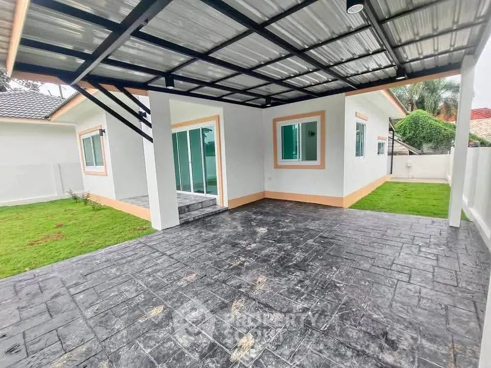 Modern single-story home with spacious covered patio and lush green lawn.