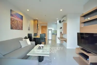 Modern living room with sleek furniture and open kitchen layout in a stylish apartment.