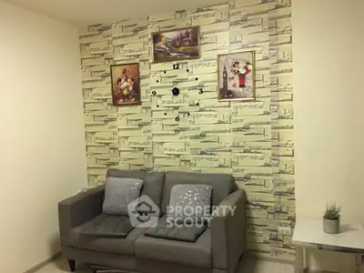 Cozy living room with stylish wall clock and elegant decor, featuring a comfortable gray sofa and decorative paintings.