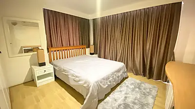 Spacious bedroom with cozy ambiance and elegant curtains, perfect for relaxation.