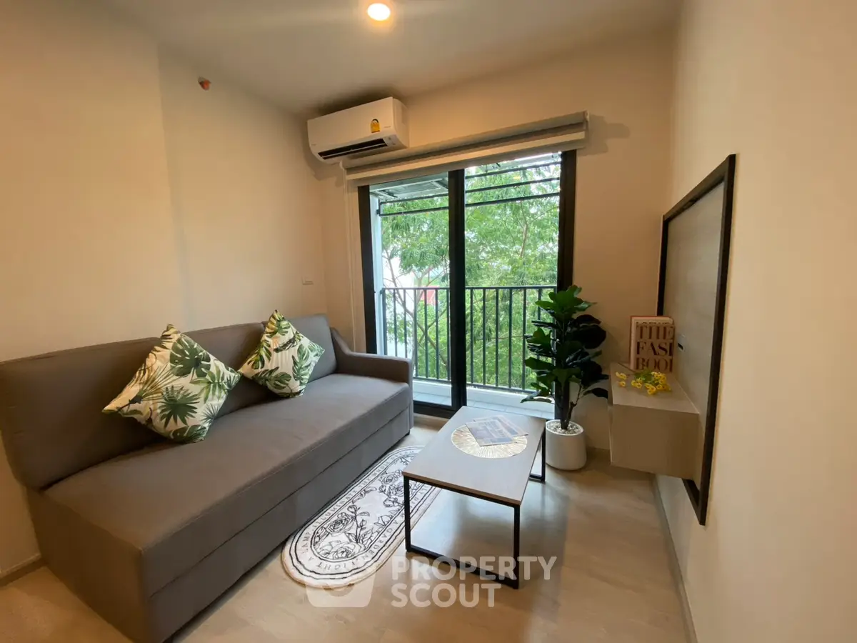 Chic living room with modern sofa, balcony view, and stylish decor in urban apartment.