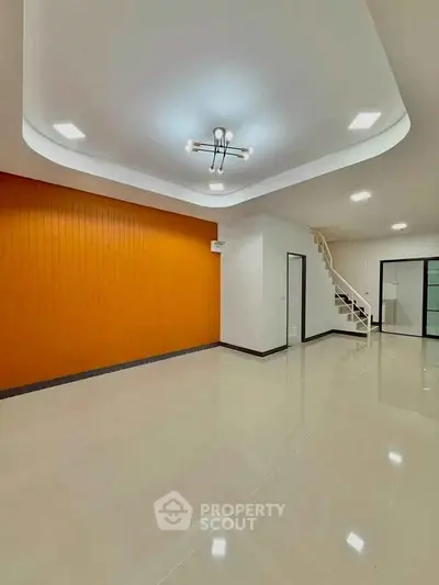 Spacious modern living room with unique ceiling design and staircase