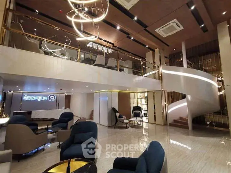 Luxurious modern lobby with elegant seating and spiral staircase in upscale building.
