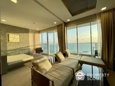 Luxurious corner unit with panoramic ocean views, featuring floor-to-ceiling windows, modern furnishings, and a serene color palette.