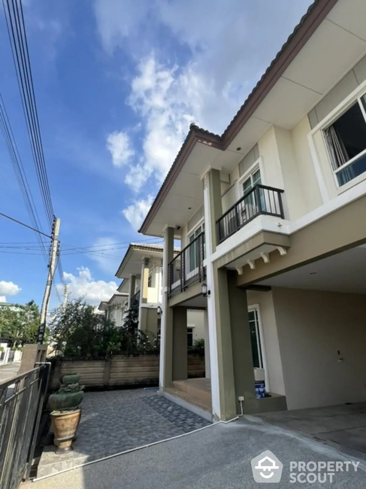 Modern two-story house with spacious driveway and elegant balcony