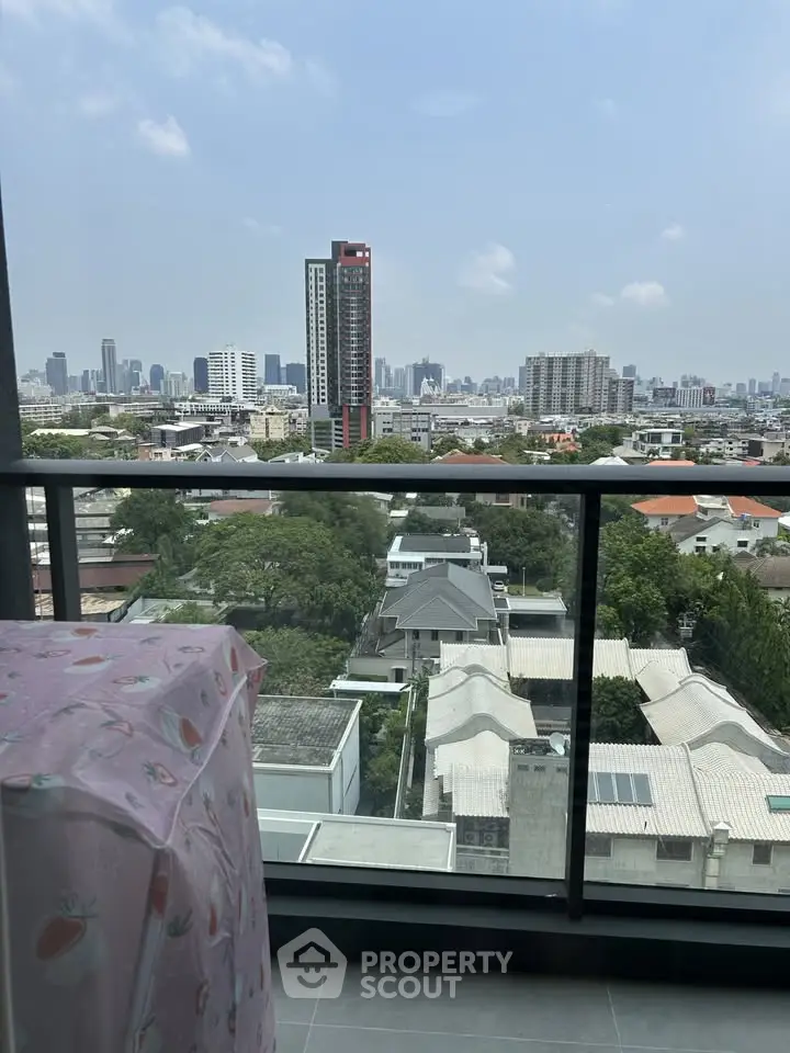 Stunning cityscape view from a high-rise balcony, showcasing urban skyline and residential area.
