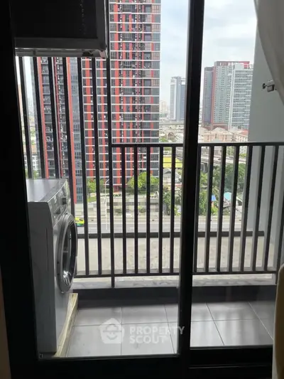 Modern balcony with washing machine and city view in high-rise apartment.