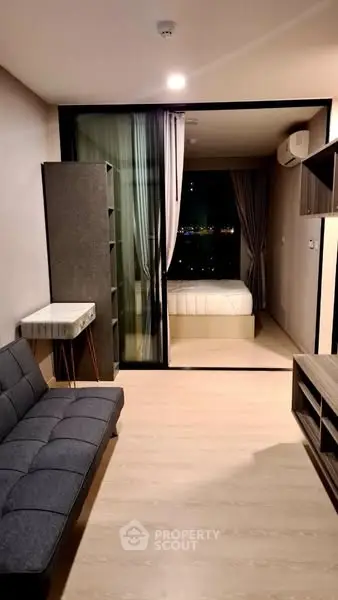 Modern apartment with open layout, featuring a cozy living area and bedroom with city view.