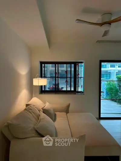 Cozy living room with modern beige sofa and stylish ceiling fan, perfect for relaxation.