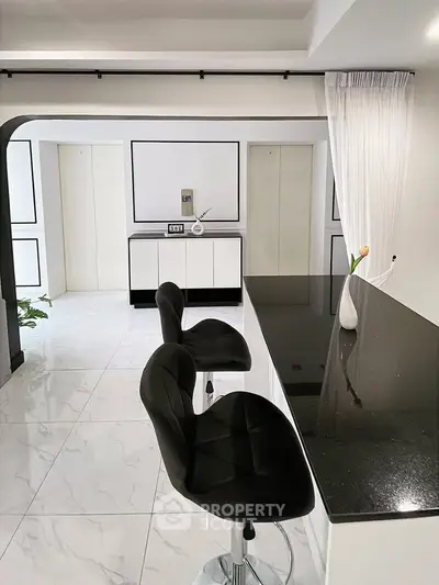 Sleek modern kitchen with black granite countertop and stylish bar stools