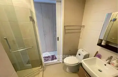 Modern bathroom with glass shower and sleek fixtures in contemporary apartment.