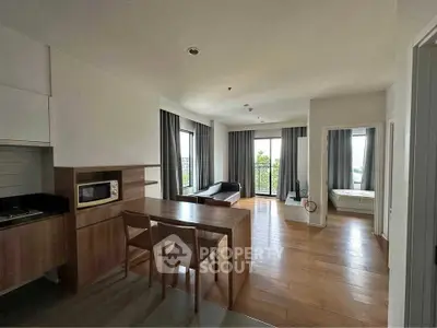 Spacious modern living room with open kitchen and balcony view