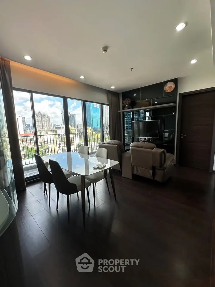 Modern living room with city view, elegant dining area, and sleek furnishings.