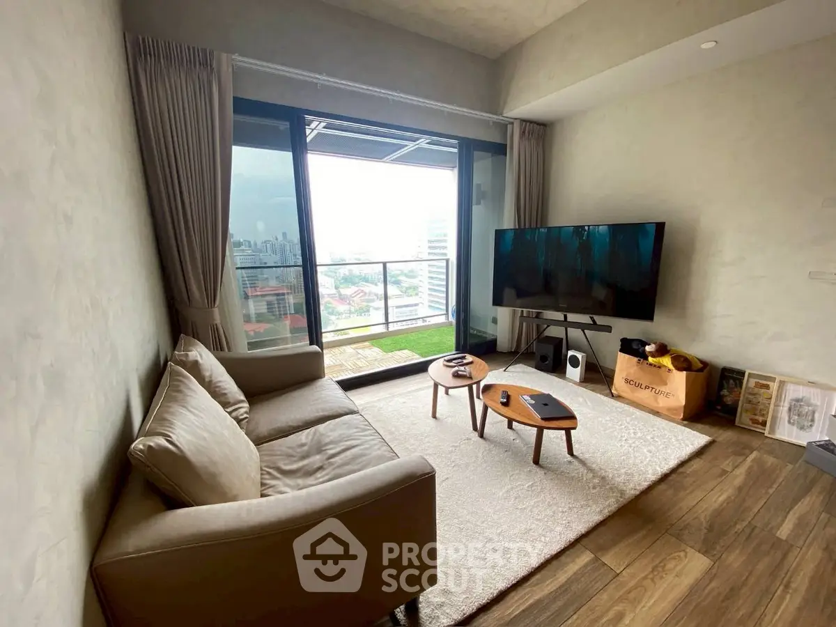Modern living room with large balcony and city view, featuring cozy sofa and sleek TV setup.