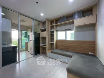 Modern living room with built-in seating and open kitchen layout in a stylish apartment.