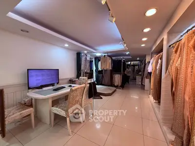 Spacious retail space with elegant clothing displays and modern lighting.