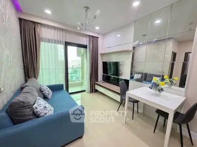 Modern living room with blue sofa, mirrored wall, and city view balcony in a stylish apartment.