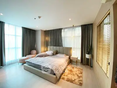 Luxurious bedroom with modern decor and large windows in a high-end apartment.