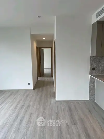 Spacious modern apartment interior with sleek flooring and open layout.