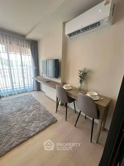 Modern living room with air conditioning and dining area, featuring large window and stylish decor.