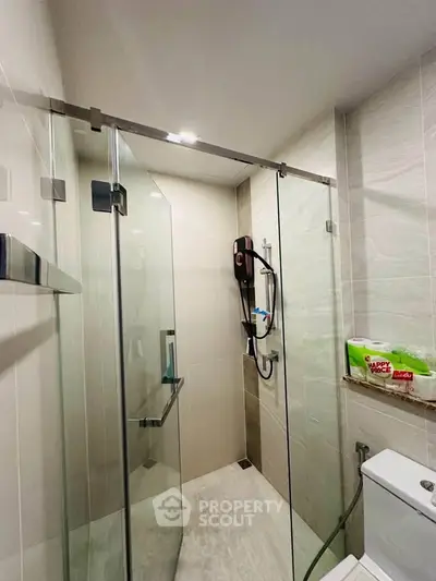 Modern bathroom with glass shower enclosure and sleek fixtures