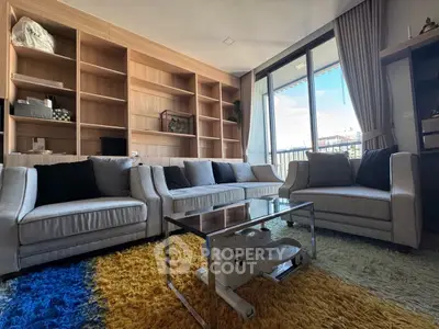 Spacious living room with modern furniture and large windows offering natural light.