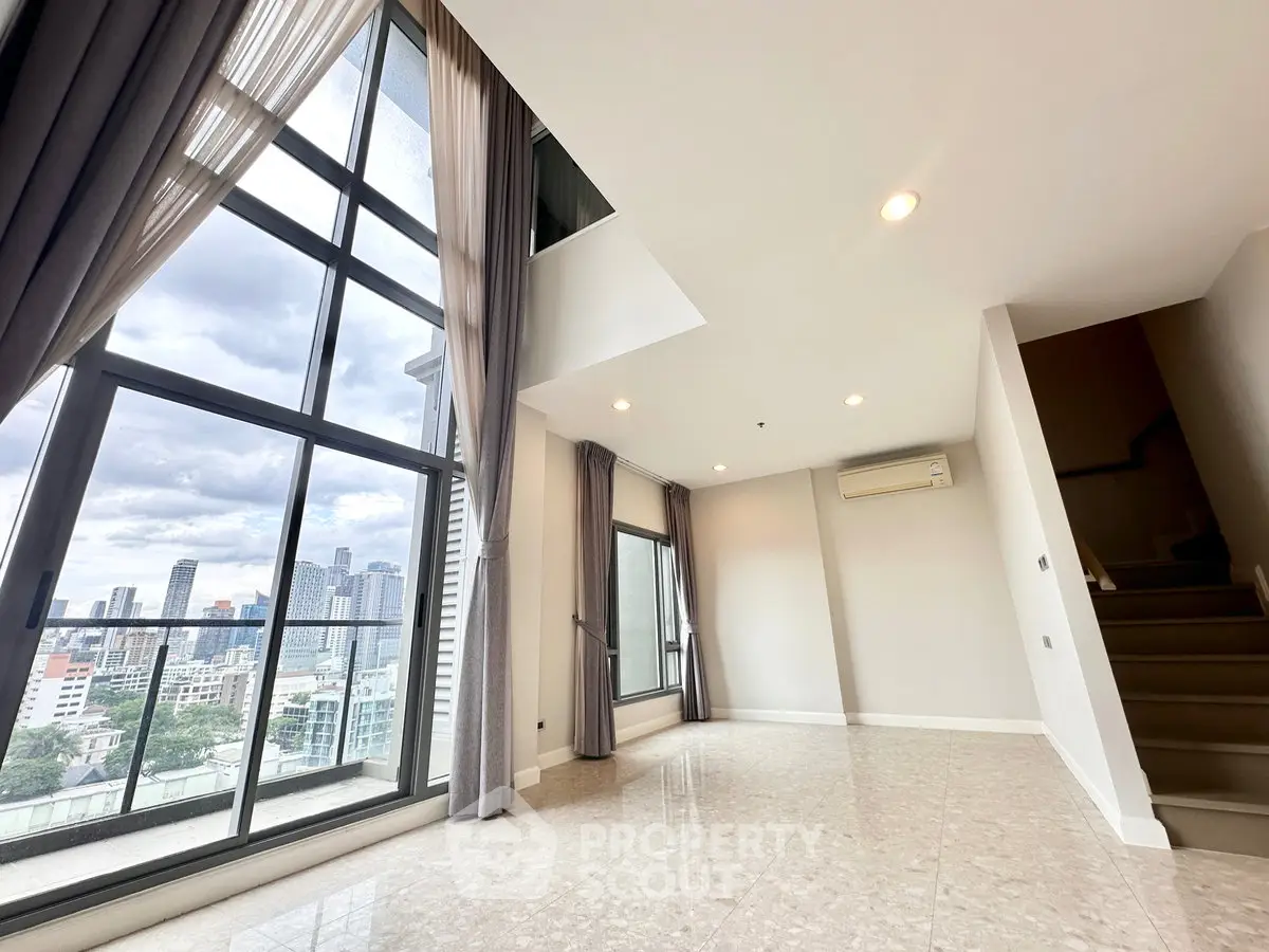 Spacious modern living room with large windows and city view, featuring elegant curtains and polished floors.