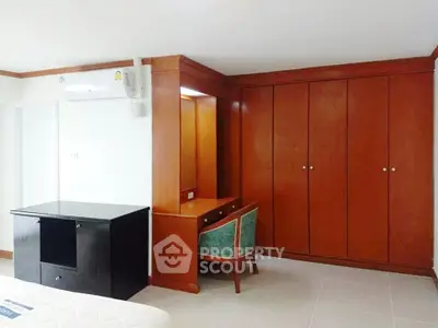 Spacious bedroom with built-in wooden wardrobe and dressing table