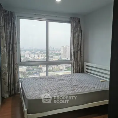 Spacious bedroom with stunning city view from large window.