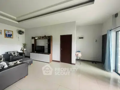 Spacious living room with modern decor and ample natural light.