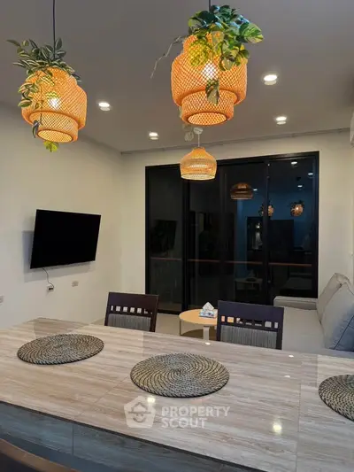 Modern living room with stylish lighting and large glass doors leading to a balcony.