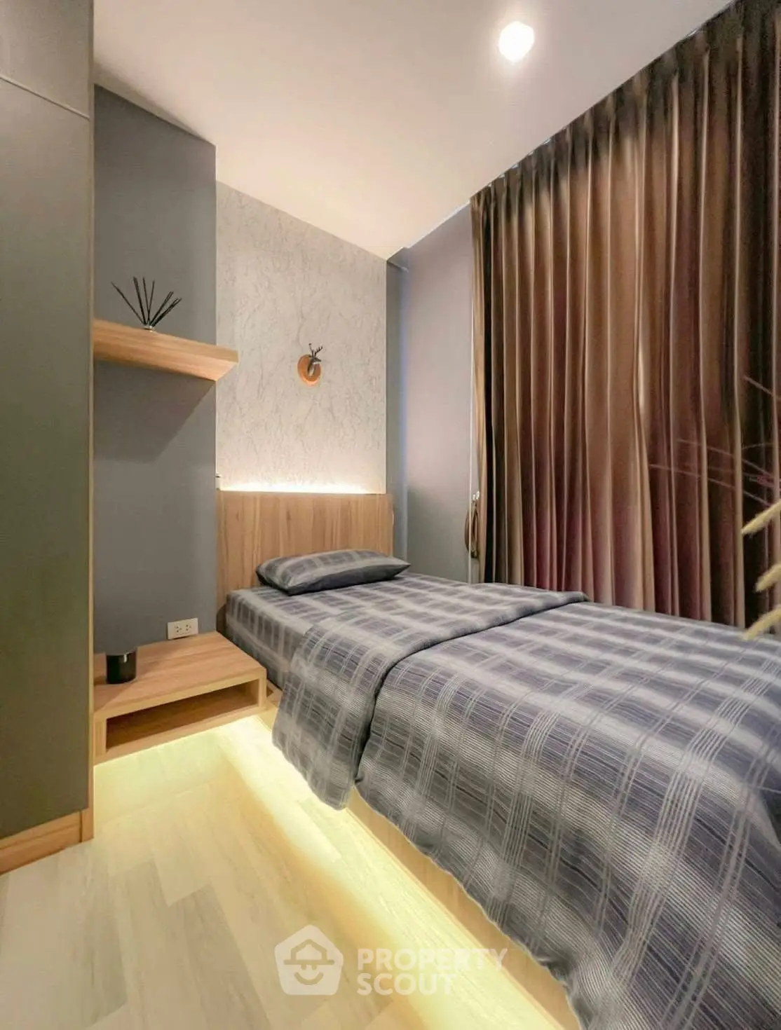 Modern bedroom with stylish decor and ambient lighting, featuring a cozy single bed and elegant curtains.