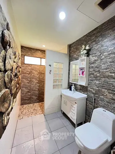 Modern bathroom with stone accent wall and sleek fixtures
