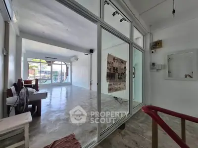 Spacious open-plan interior with large windows and polished concrete floors, ideal for versatile living or office space.