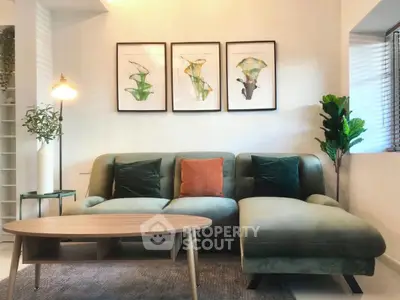 Stylish living room with modern green sofa, elegant decor, and natural light.