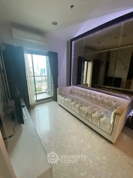 Modern living room with plush sofa and city view balcony