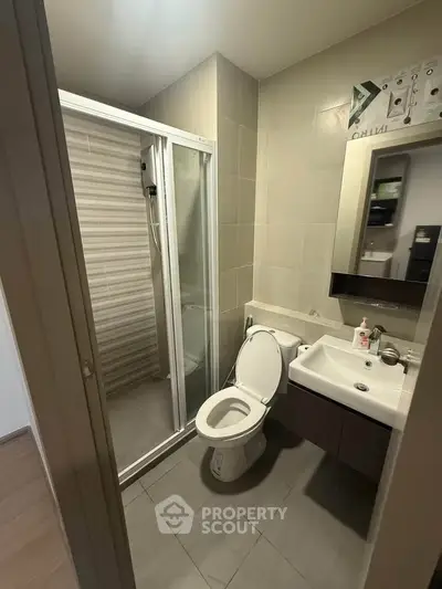 Modern bathroom with shower and sleek fixtures in contemporary apartment.